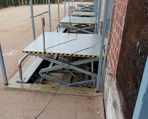 Raised platform in a pit along a brick wall