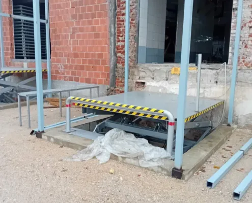 Scissor lift platform installed in a pit outside a building
