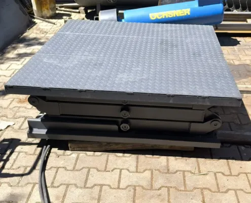 Lowered hydraulic scissor lift platform with a checker plate deck