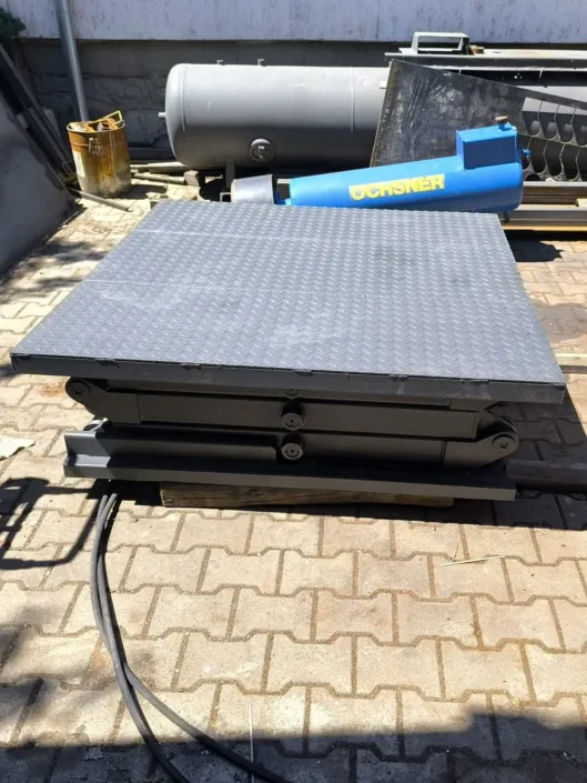Lowered hydraulic scissor lift platform with a checker plate deck